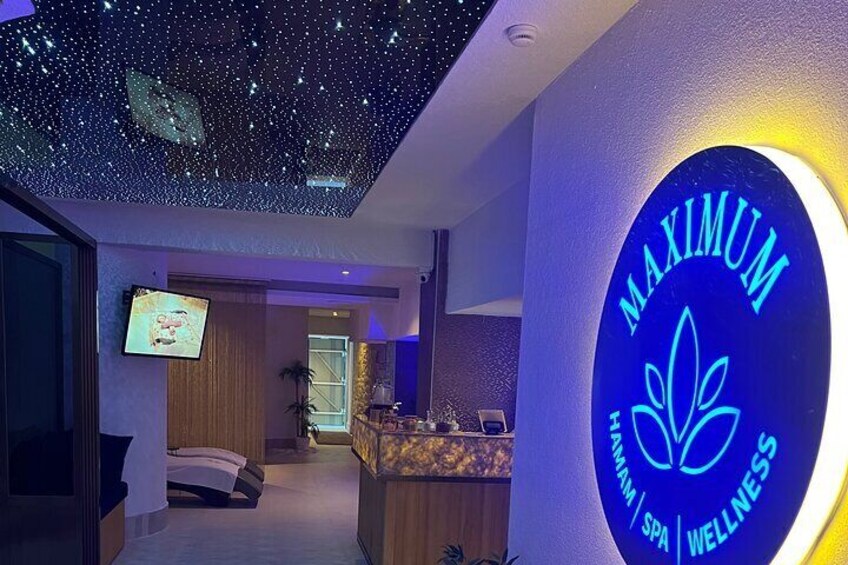 A spa interior with a starry ceiling, a reception desk, and a bed. 2