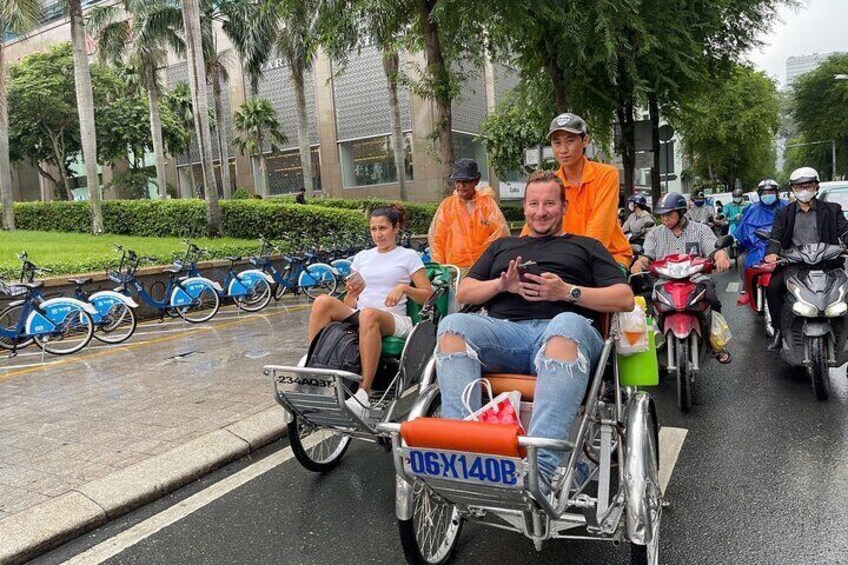A group of people on motorized wheelchairs on a wet street. 2
