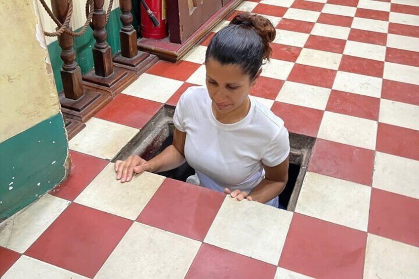 A person sitting in a narrow opening in a red and white checkered floor. 5