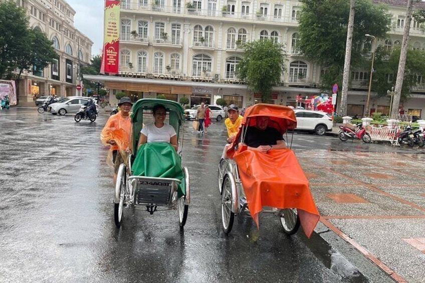 Two rickshaws on a wet street with buildings in the background. 3
