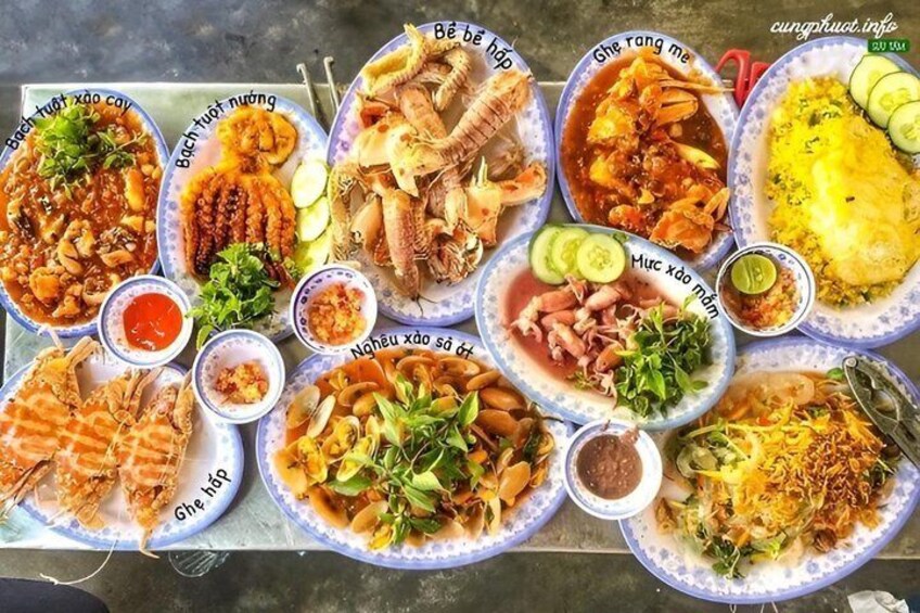 A variety of dishes on plates, including seafood and rice dishes, with labels in Vietnamese. 3