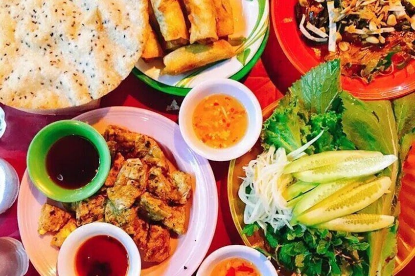 A variety of dishes including fried items, a plate with sliced cucumbers, and bowls of sauces. 4