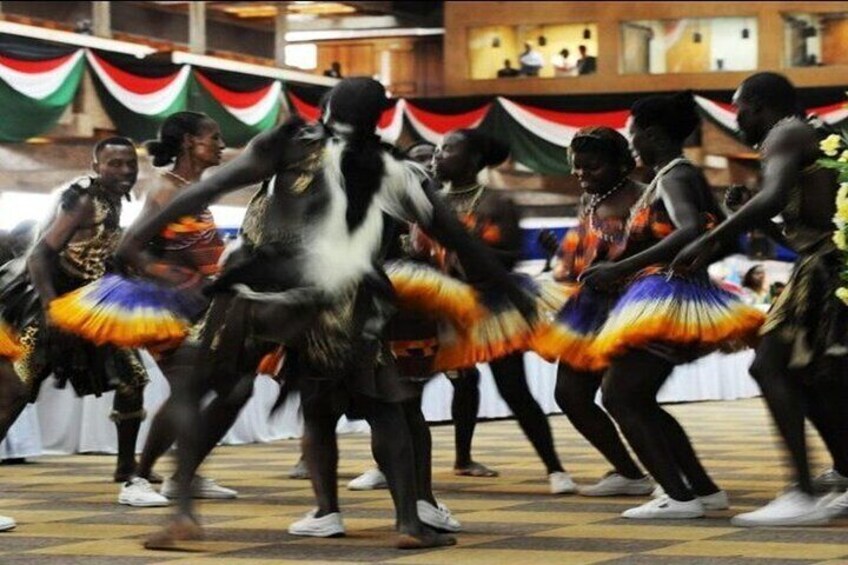 A group of dancers in colorful costumes performing on a patterned floor. 5