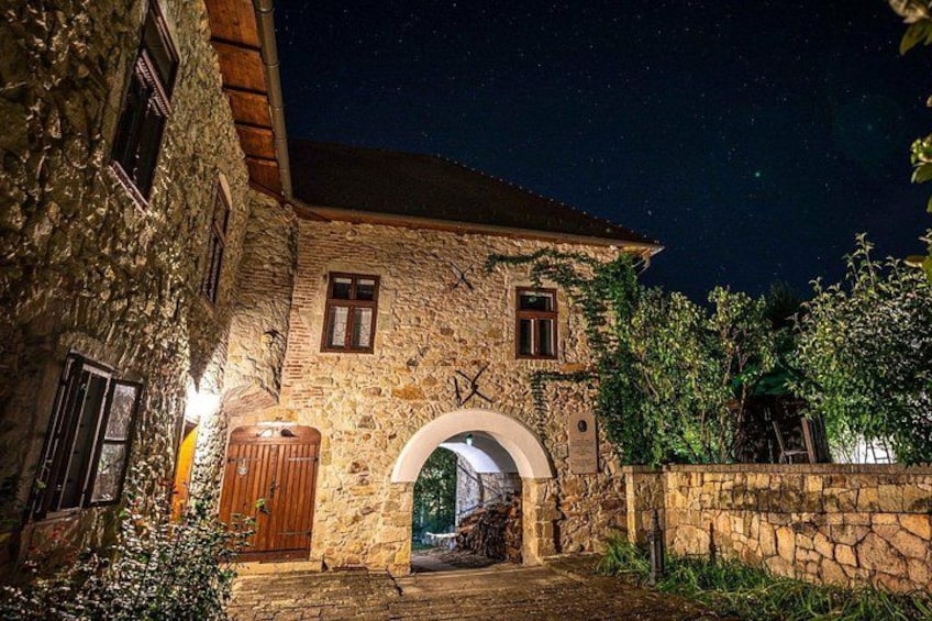 A stone building with a wooden door and an arched entranceway. 5