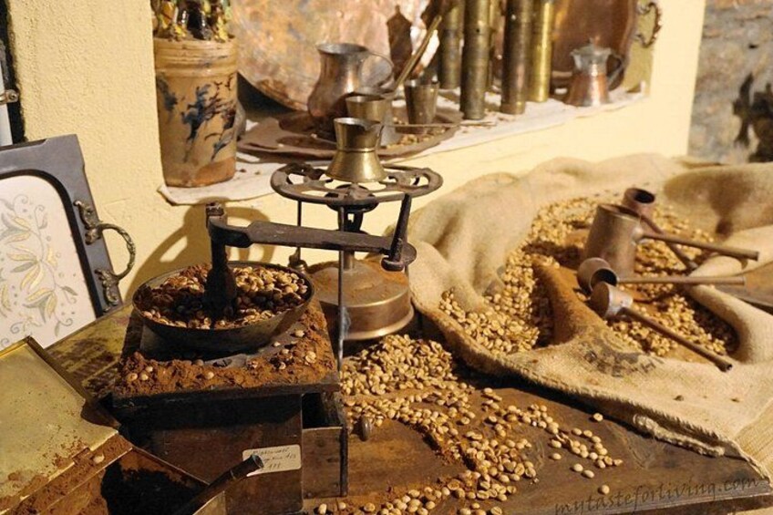 A rustic scene with a coffee grinder, scattered coffee beans, and vintage kitchen utensils. 4