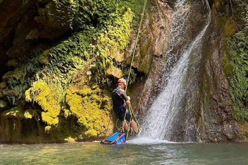 Een persoon waterskiën op een rivier, met een waterval op de achtergrond. 1
