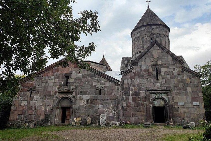 A stone church with a bell tower and a large arched entrance. 2