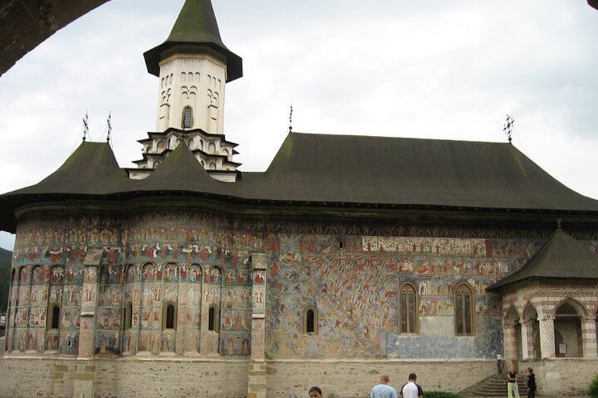 Un bâtiment historique doté d’une tour, de fenêtres en arc de cercle et de peintures murales aux motifs élaborés. 4