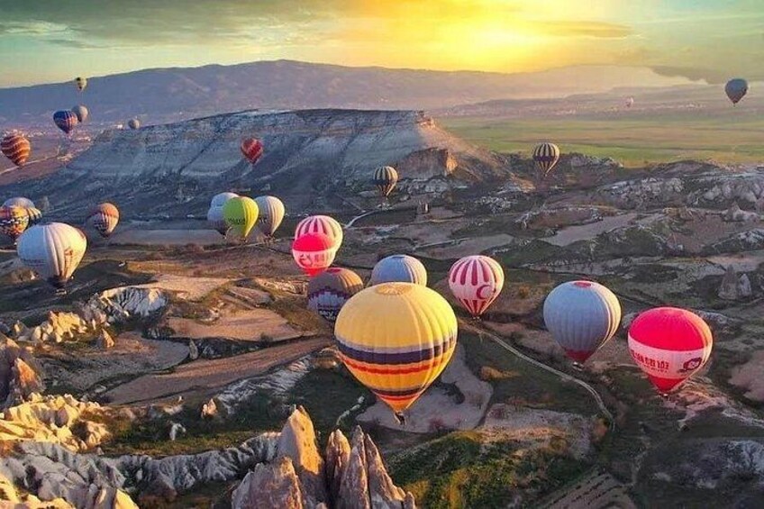 Eine Landschaft mit zahlreichen bunten Heißluftballons. 2