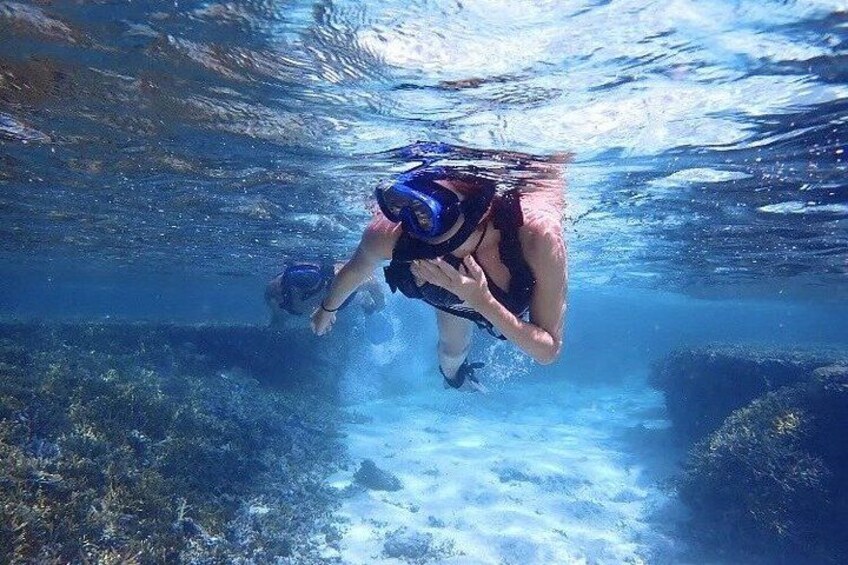 Una persona bajo el agua, nadando con un snorkel y máscara. 1