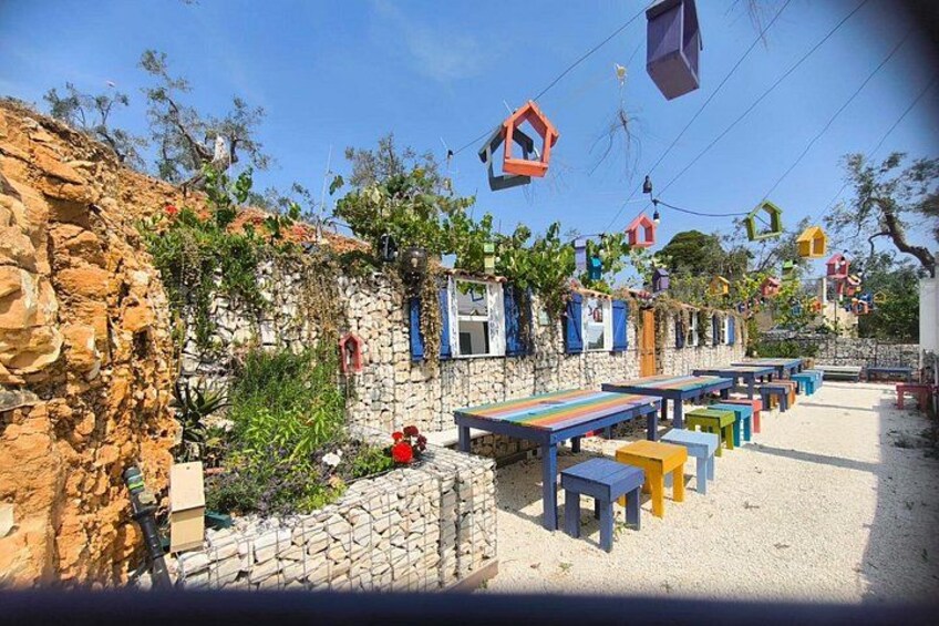 A stone wall with colorful wooden benches and hanging decorations. 3