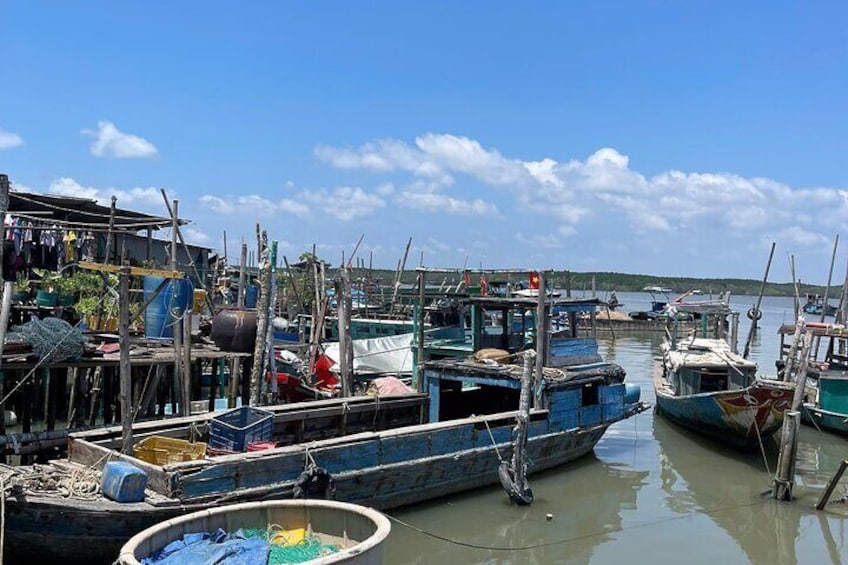 A harbor with boats docked, wooden structures, and a clear sky. 4