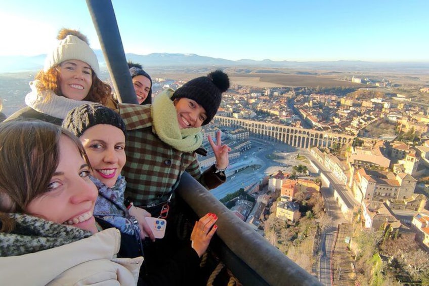 Eine Gruppe von Menschen in einer Seilbahn mit Blick auf eine Stadt und einem markanten Aquädukt. 3