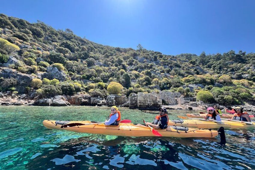 Persone che fanno kayak in acque limpide con montagne sullo sfondo. 2