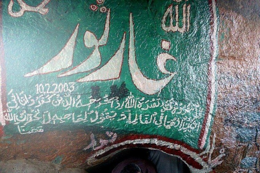 A wall with Arabic calligraphy and text, including a date. 5