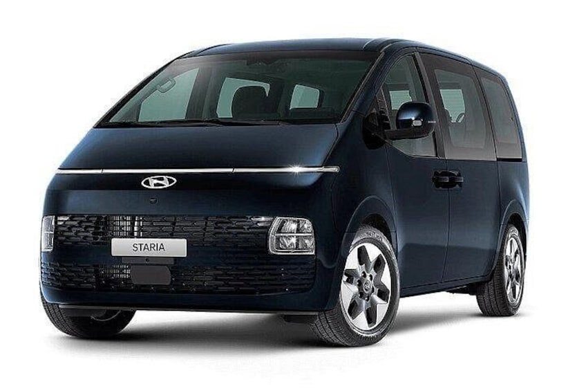 A dark blue Hyundai STARIA van with a visible front grille, headlights, and side mirrors. 2