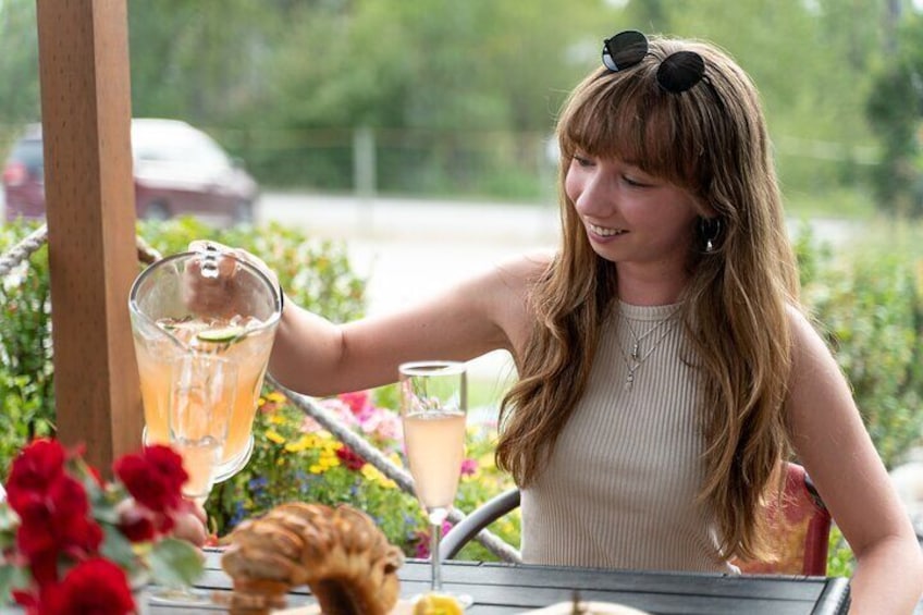 A person pouring a drink from a pitcher into a glass. 1