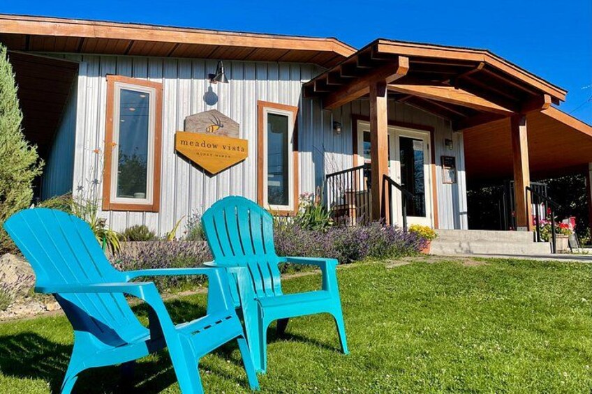 A building with a sign reading 'meadow vistas' and two blue Adirondack chairs in front. 2