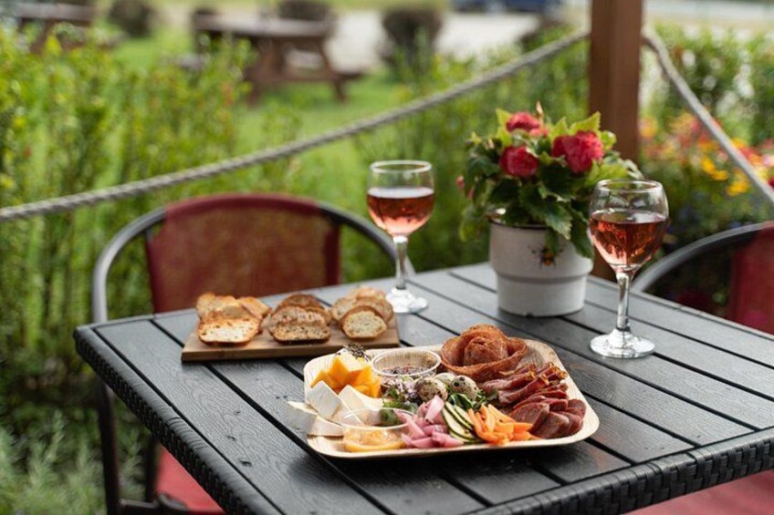 An outdoor dining table with a charcuterie board, wine glasses, and a potted plant. 5