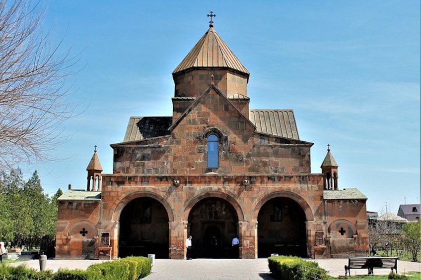 A historic church with a central dome, arched entrance, and two bell towers. 3
