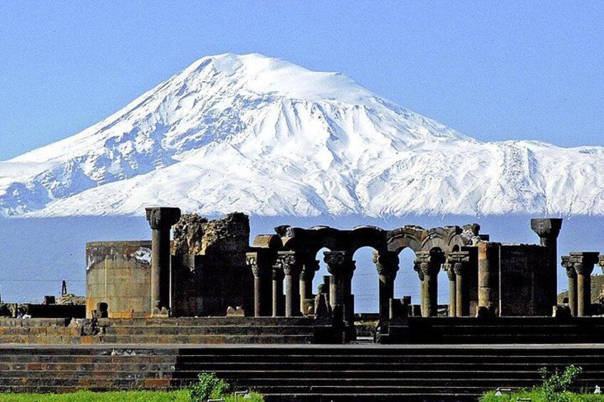 Ancient ruins with columns in front of a snow-capped mountain. 2