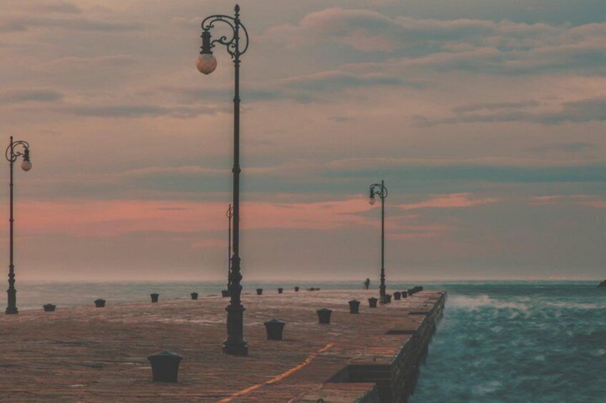 Une jetée en bois s’avançant dans la mer, agrémentée de lampadaires et de bornes. 5