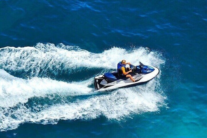A person jet-skiing on a clear blue water body. 5