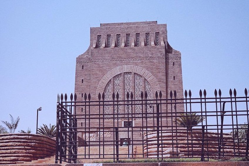 A large brick building with a central arched window and a decorative facade. 1
