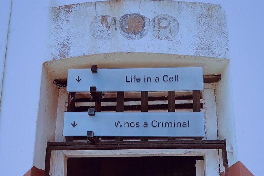 A sign with arrows pointing downwards, labeled 'Life in a Cell' and 'Whos a Criminal'. 2