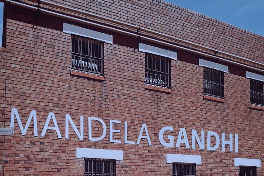 A brick building with the name 'MANDELA GANDHI' displayed prominently. 4