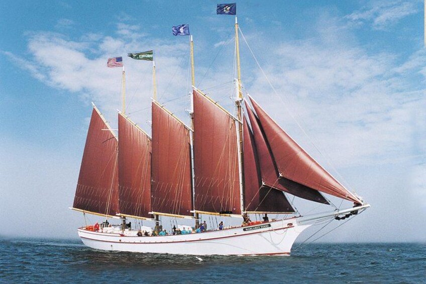 A sailboat with multiple sails on a body of water. 2