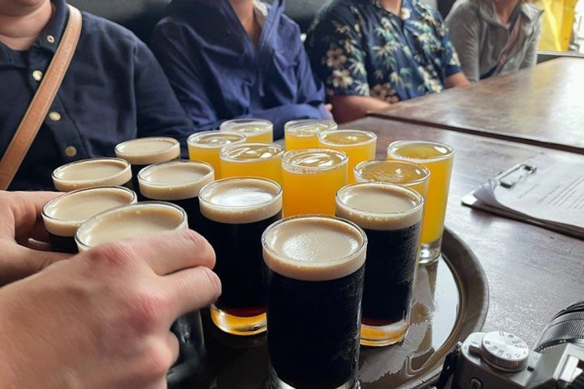 A tray with several glasses of beer and orange juice. 4