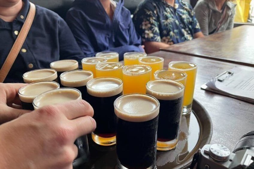 A tray with several glasses of beer and orange juice. 3