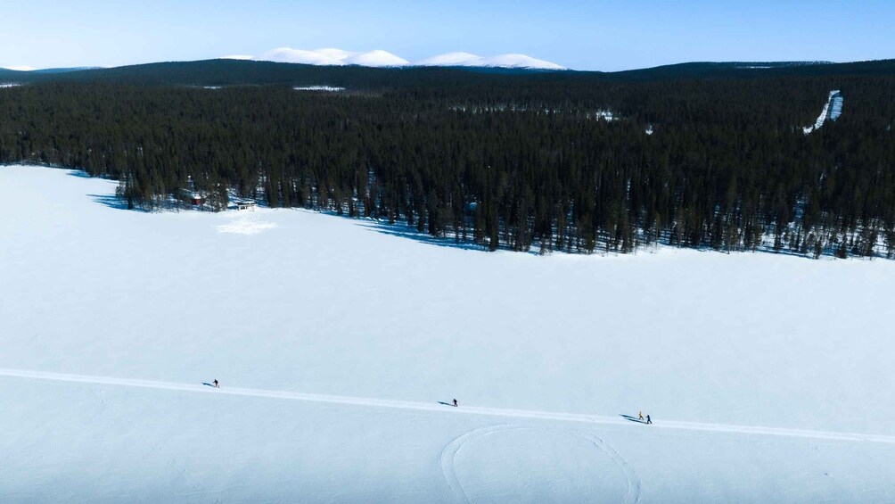 A snowy landscape with a ski slope, trees, and distant mountains. 3
