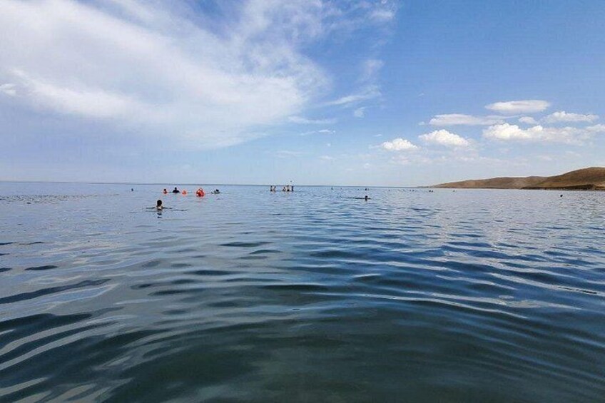 Ein ruhiger See mit Schwimmern und einer entfernten Uferlinie. 4