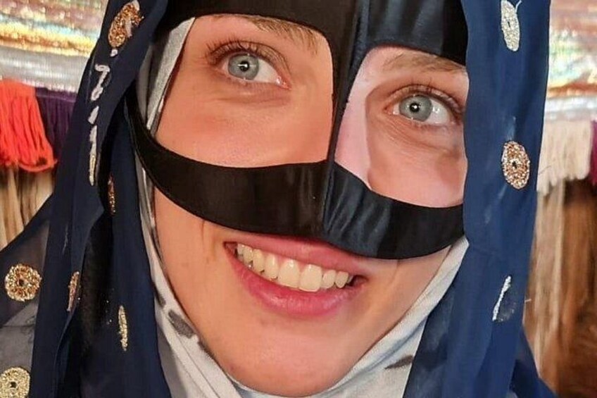 A person wearing a dark blue garment with gold embellishments. 1