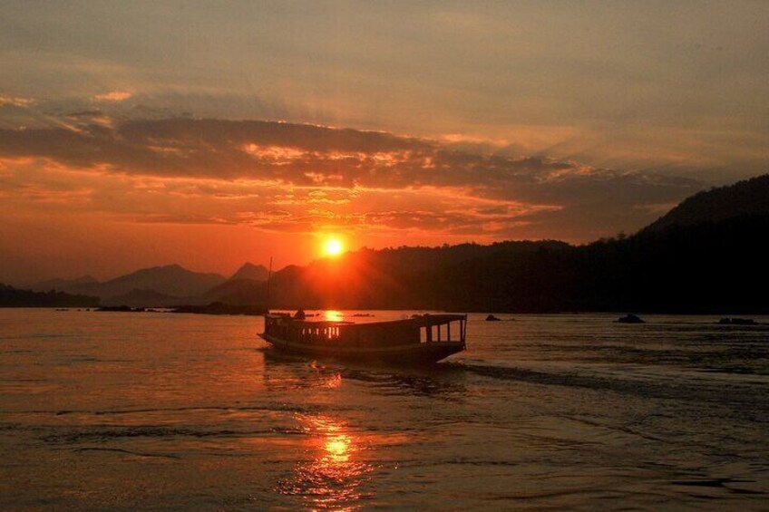 Un bote en el agua durante el atardecer, con el sol bajo en el horizonte. 4