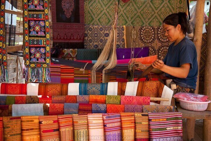 Una persona tejiendo textiles coloridos en un telar. 2