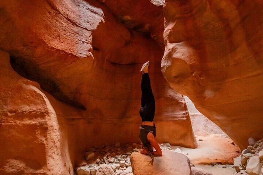 A person standing in a narrow canyon with red rock walls. 2