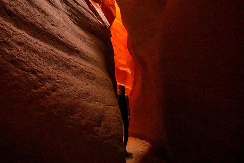 A person standing in a narrow canyon with red rock walls. 5