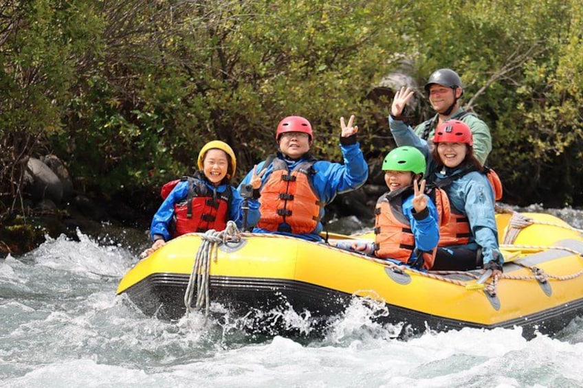 Un grupo de personas en una balsa amarilla navegando por un río rodeado de árboles. 3