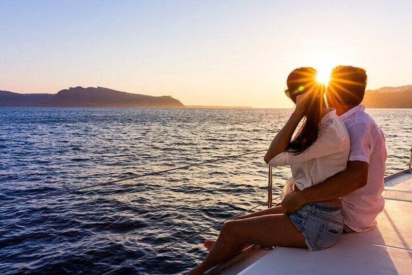 A couple embracing on a boat with a sunset in the background. 1