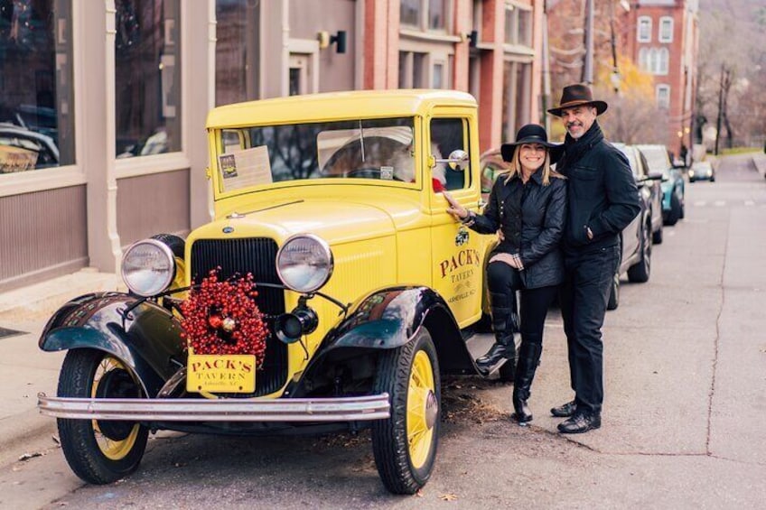 A vintage yellow Packy's Tavern car parked on a city street. 2