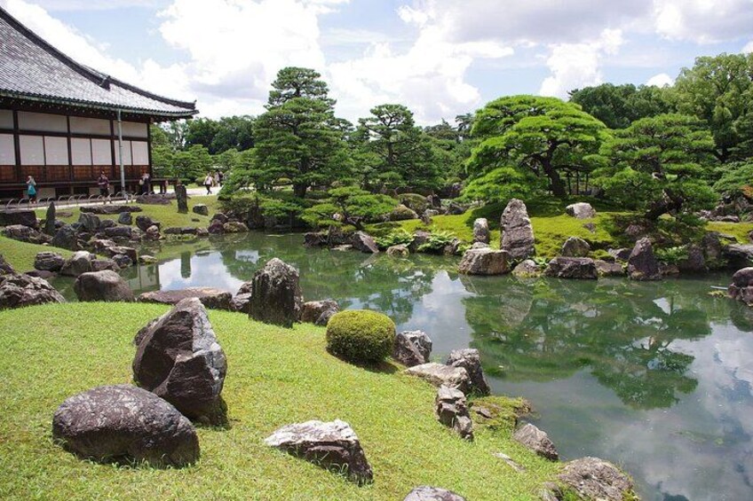 Un jardin japonais traditionnel avec un étang, des rochers et des arbres. 2