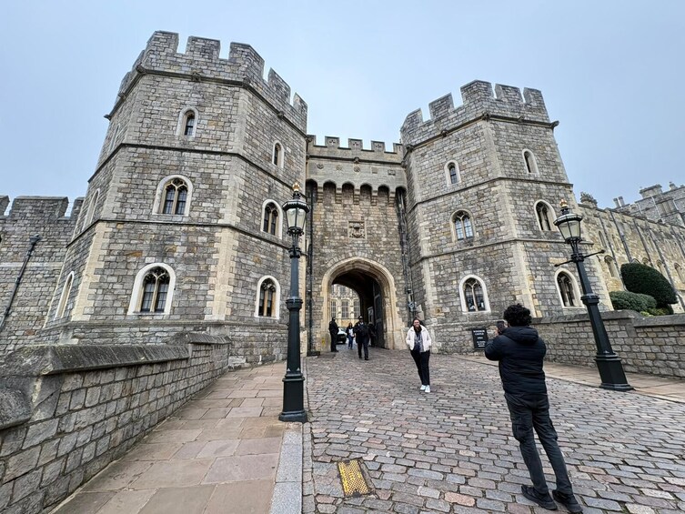 A historic stone castle with arched gateways and battlements. 2
