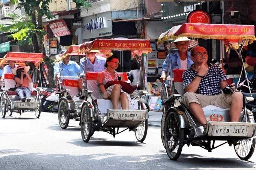 A group of people riding rickshaws on a street. 3