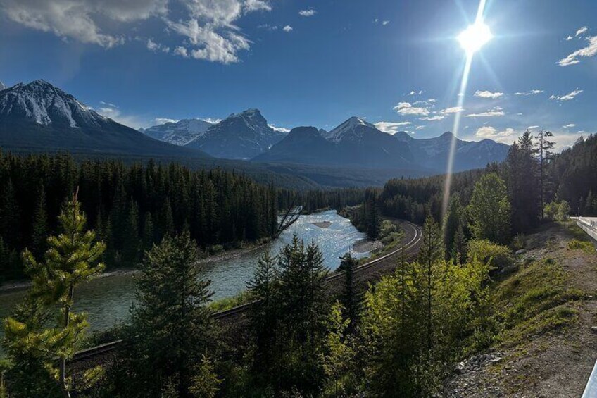 A river winding through a forest with mountains in the background. 2
