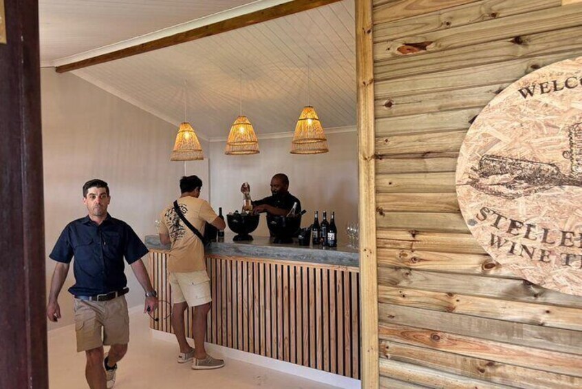 A wooden interior with a bar area, pendant lighting, and a welcome sign. 5