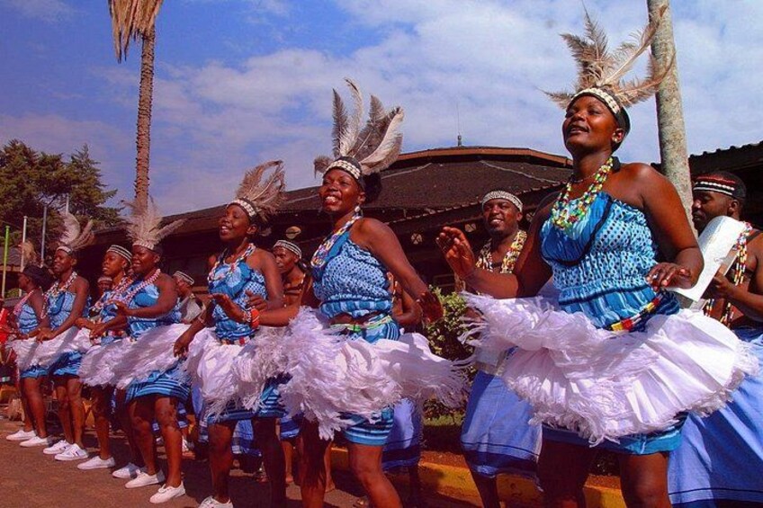 A group of people in blue and white costumes with feathered headdresses, performing a dance. 5