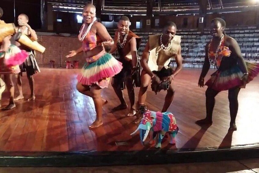 A group of dancers in colorful costumes performing on a stage. 2